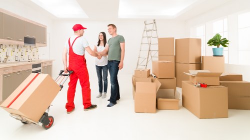Removal crew unloading boxes and furniture at a Hounslow property